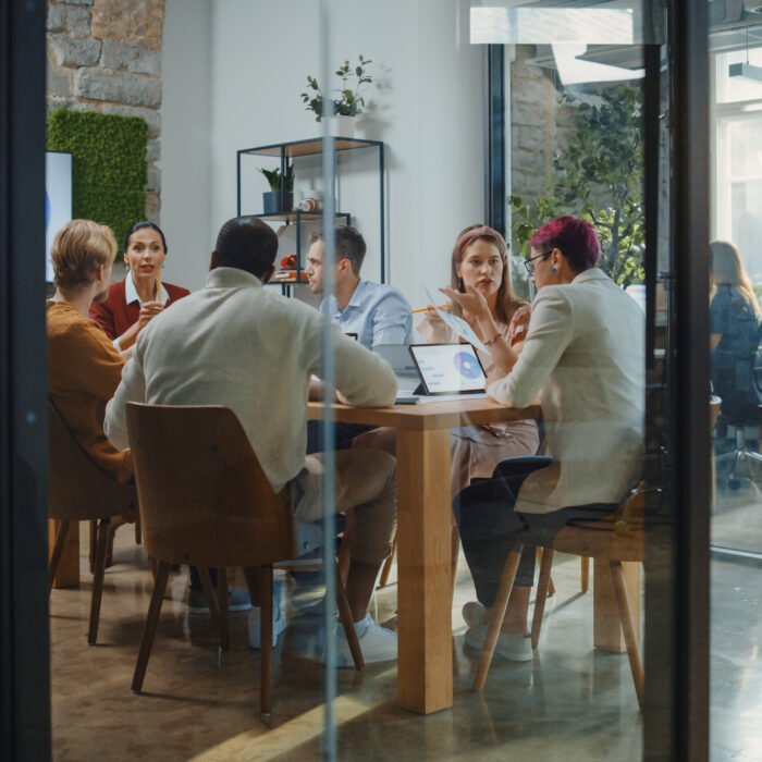 A team having an effective meeting in a glass room.